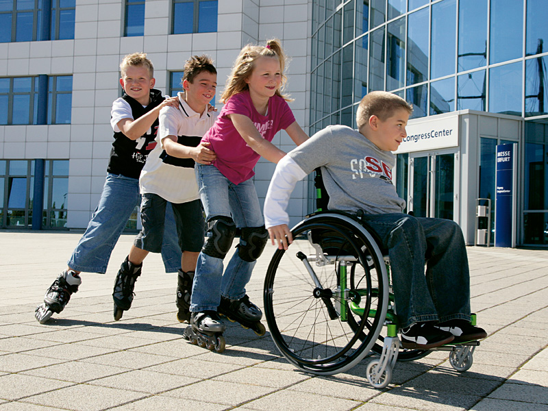 дети катают друга инвалида